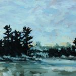 White pines on a small rocky island in an Onatrio lake emerges from the fog, a wooded shoreline in the background